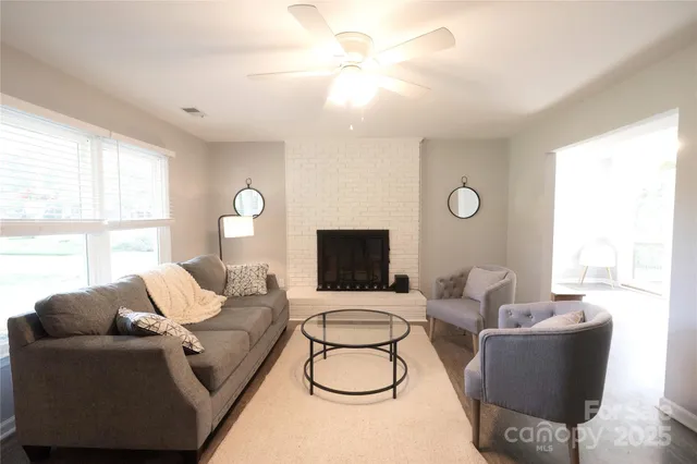 a living room with furniture a large window and a chandelier
