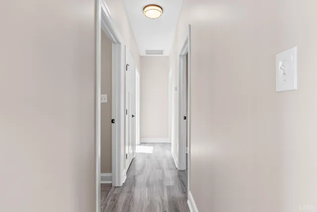 a view of a hallway with wooden floor