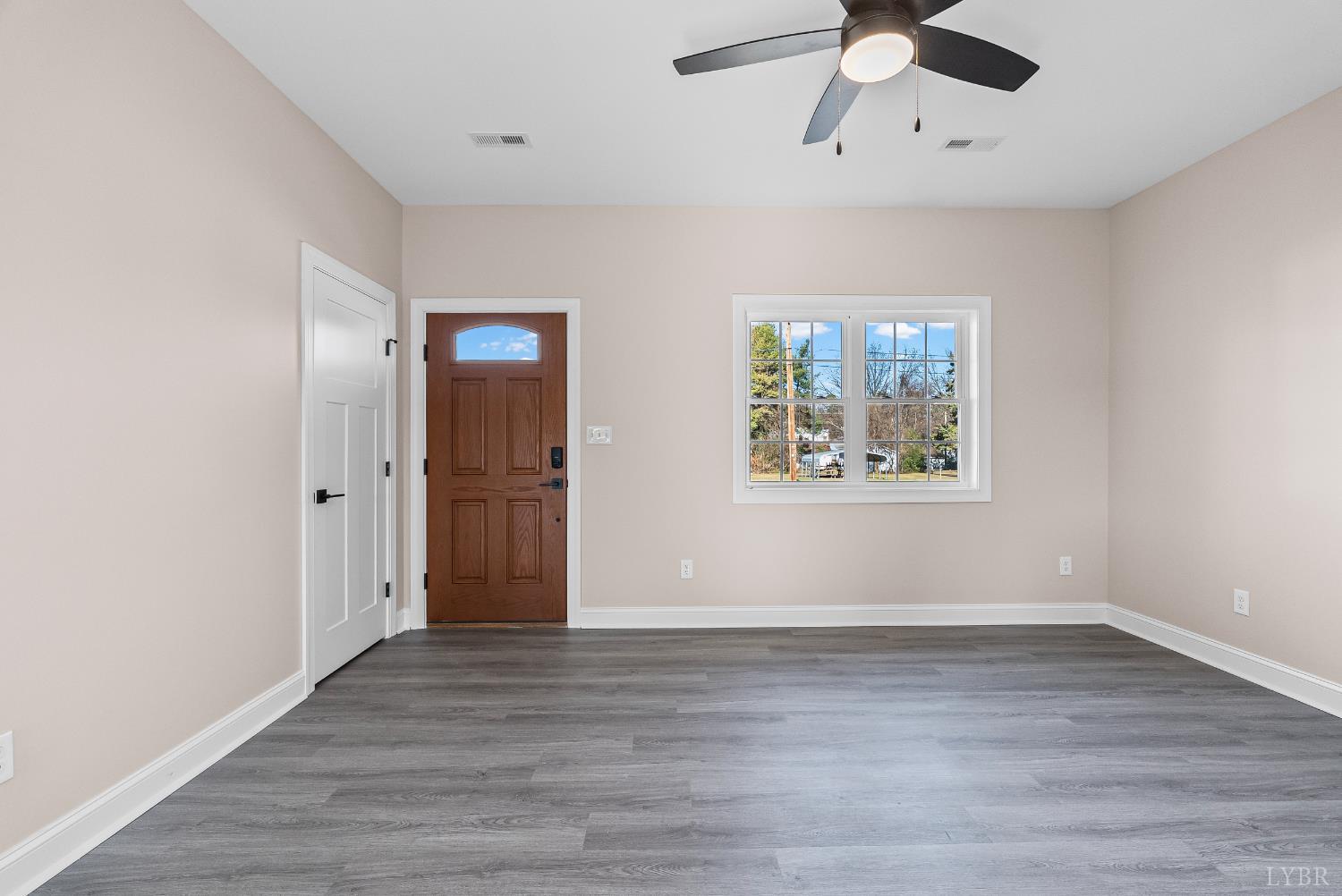 1303 4th Street Altavista, VA 24517 - Photo 3 of 36 an empty room with wooden floor ceiling fan and windows