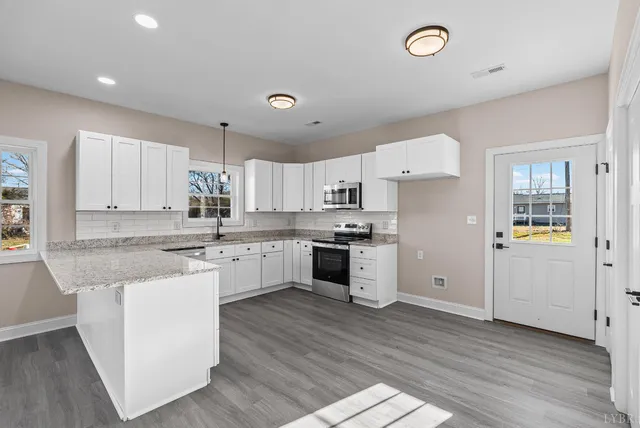a kitchen with granite countertop white cabinets and white appliances