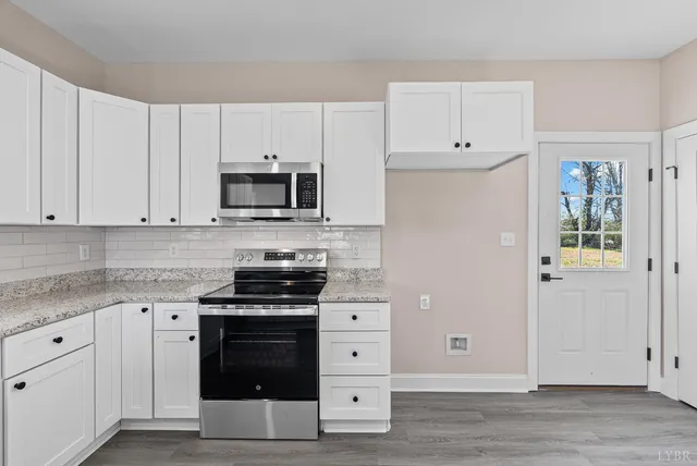 a kitchen with cabinets appliances and a wooden floor
