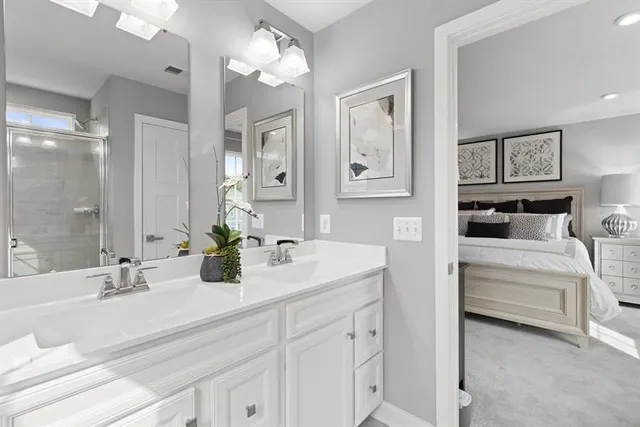 a bathroom with double vanity sinks a vanity a lamp and a mirror