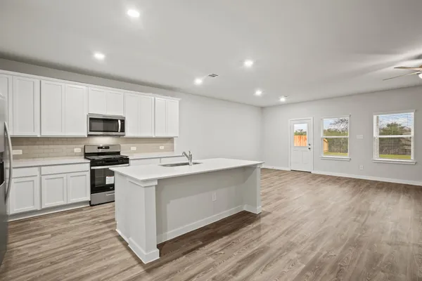 a kitchen with stove cabinets and wooden floor