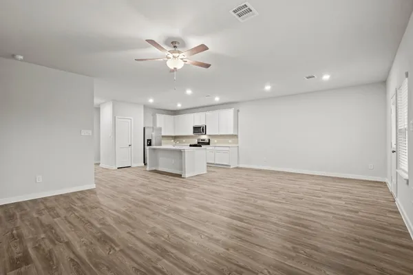 a view of kitchen with granite countertop cabinets and refrigerator