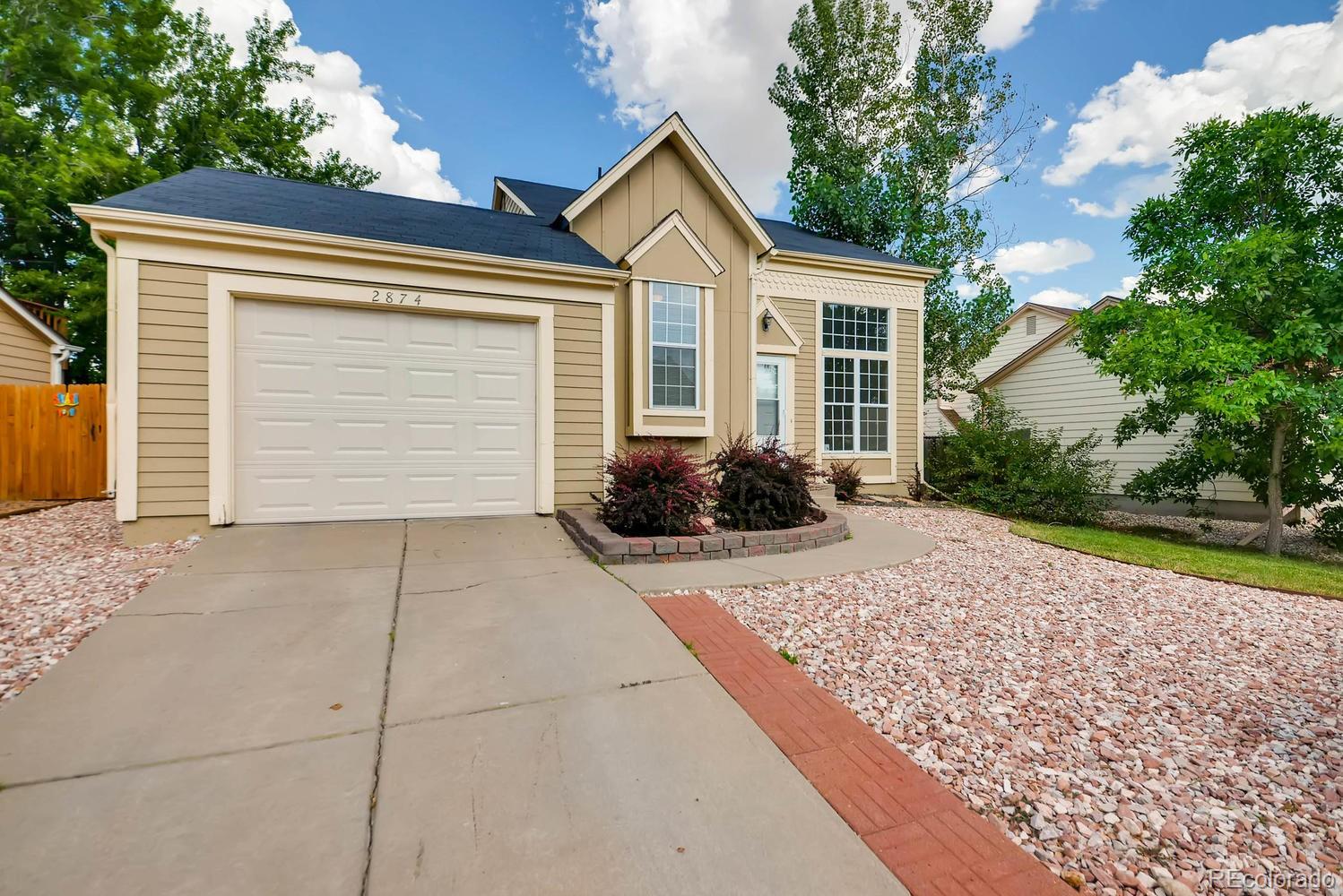 2874 South Genoa Street Aurora, CO 80013 - Photo 1 of 22 a front view of a house with a yard and garage