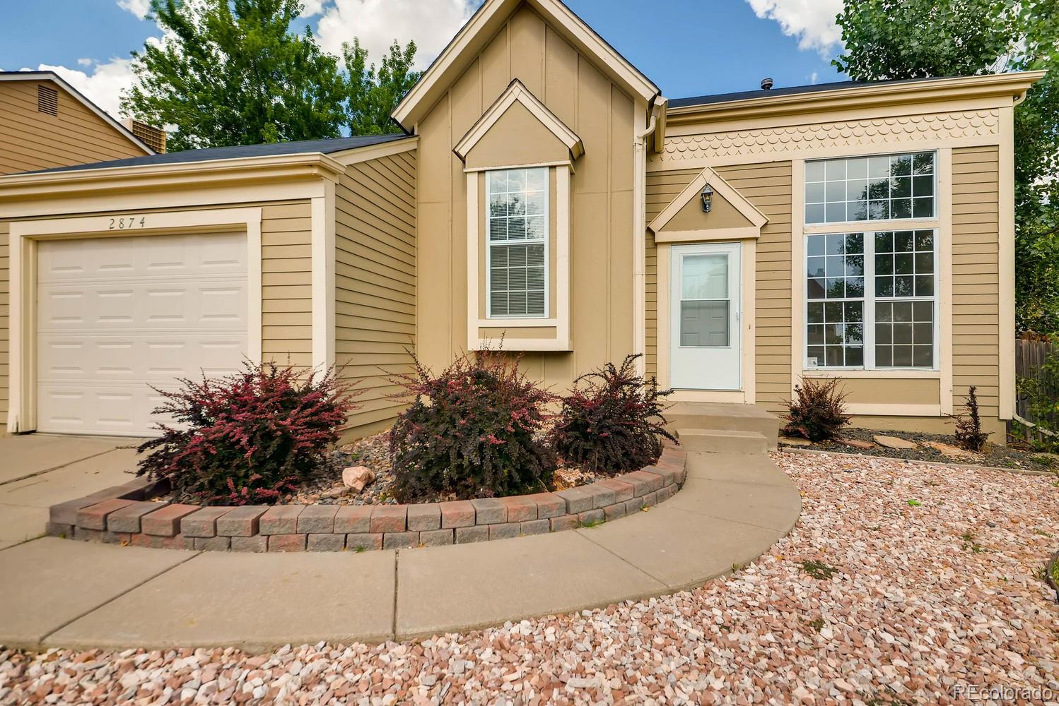 2874 South Genoa Street Aurora, CO 80013 - Photo 3 of 22 a front view of a house with garden