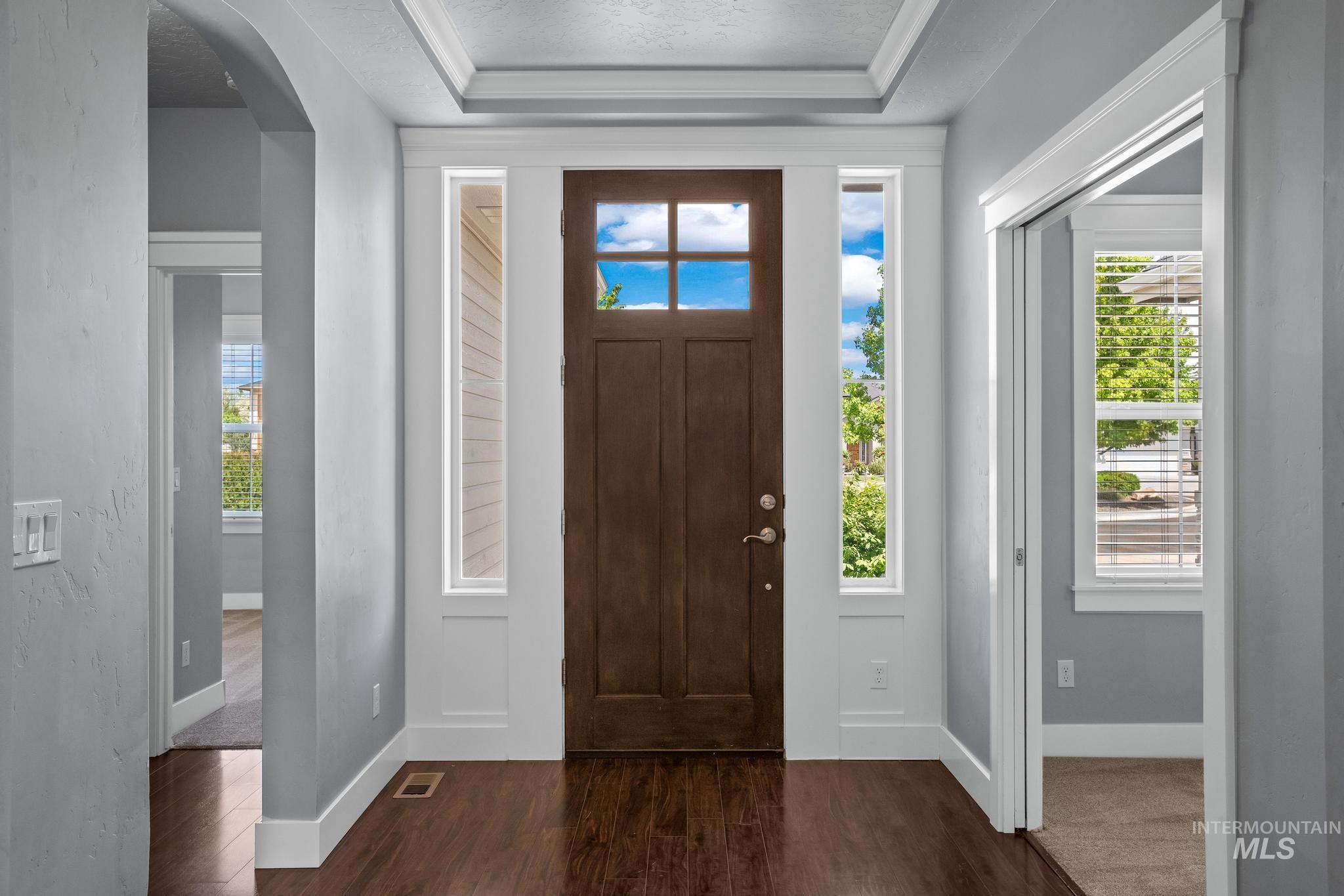 2681 East Rhyolite Court Nampa, ID 83686 - Photo 5 of 48 Entryway featuring a dark wood door with glass paneling, flanked by vertical sidelight windows