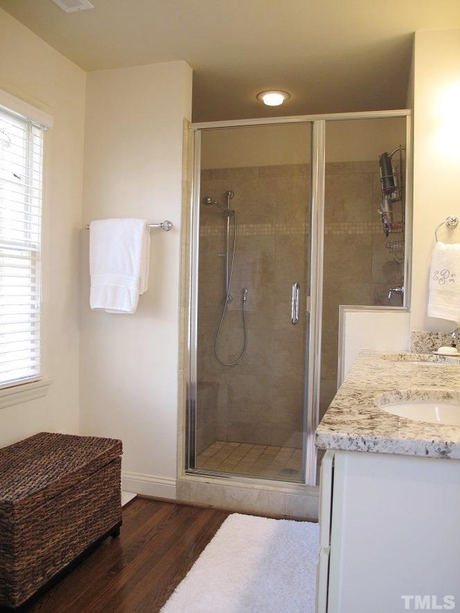2405 Tyson Street Raleigh, NC 27612 - Photo 12 of 24 a bathroom with a granite countertop sink a mirror and shower