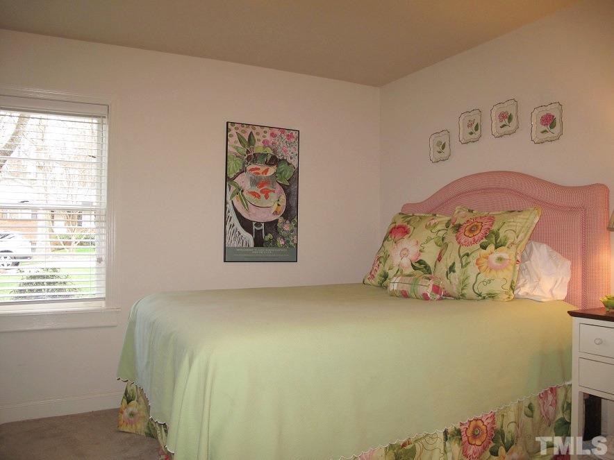 2405 Tyson Street Raleigh, NC 27612 - Photo 16 of 24 a bed sitting in a bedroom next to a window