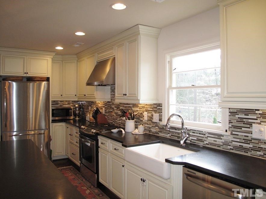 2405 Tyson Street Raleigh, NC 27612 - Photo 8 of 24 a kitchen with a sink appliances cabinets and a counter top space