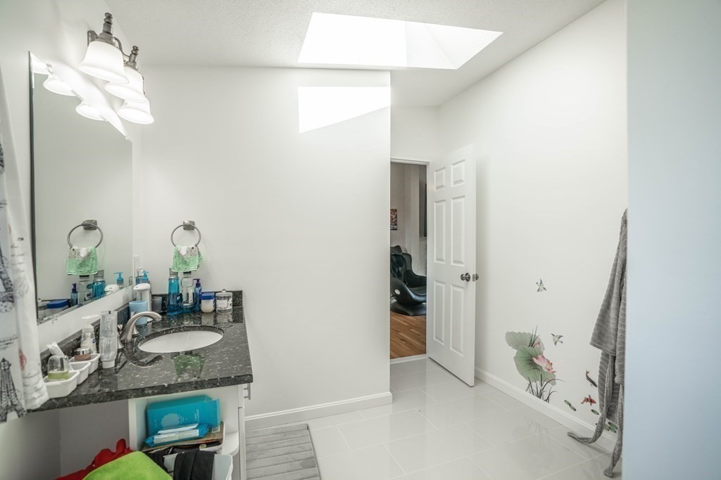 55 Gates Road Saugus, MA 01906 - Photo 17 of 42 a bathroom with a granite countertop sink and a mirror
