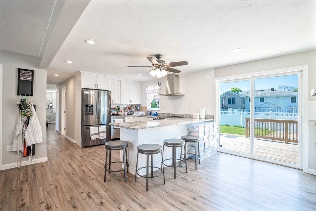 55 Gates Road Saugus, MA 01906 - Photo 3 of 42 a kitchen with stainless steel appliances a dining table chairs and wooden floor