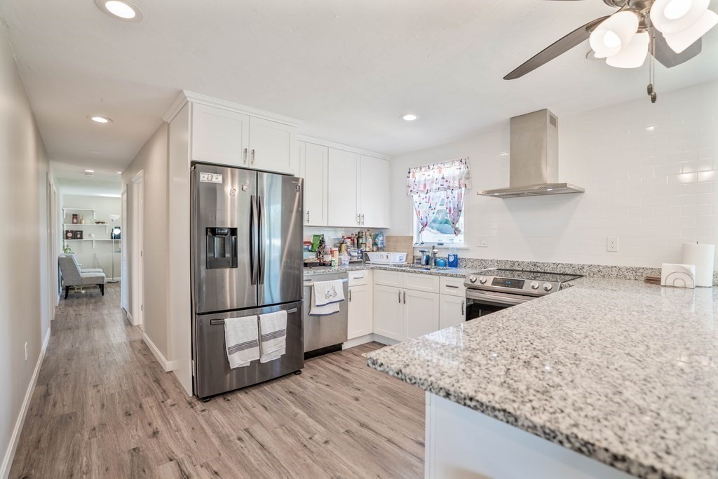 55 Gates Road Saugus, MA 01906 - Photo 7 of 42 a kitchen with granite countertop a refrigerator oven a sink and white cabinets