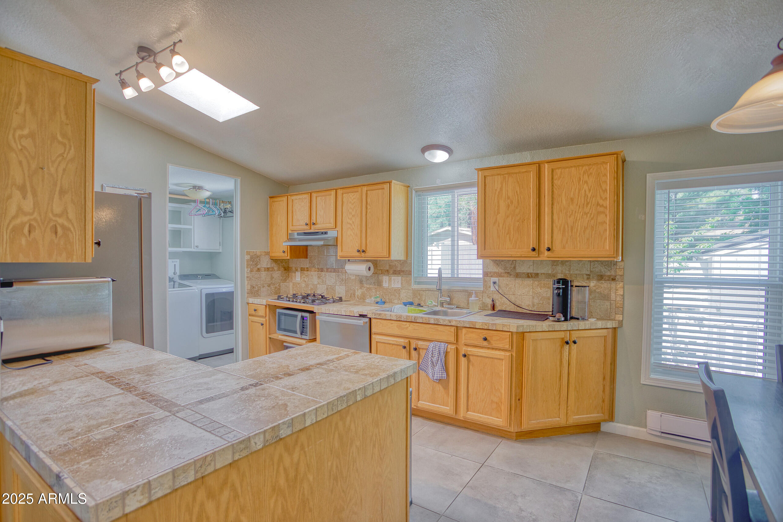 17090 Iron Springs Road Munds Park, AZ 86017 - Photo 22 of 68 a kitchen with a stove a sink a refrigerator and island