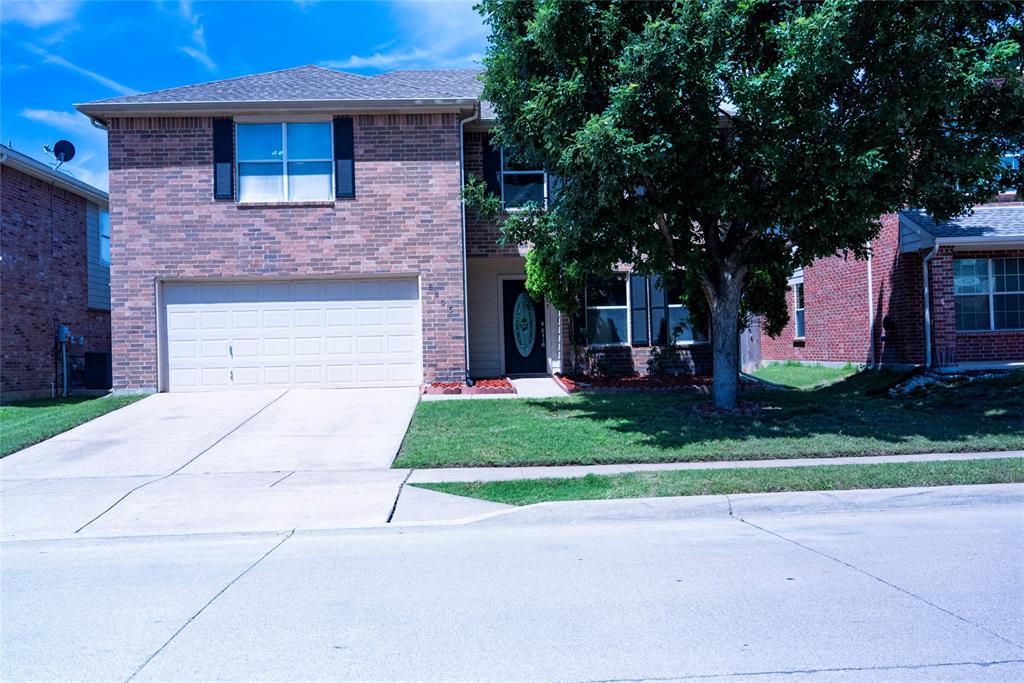 8805 Graywolf Ridge Trail Fort Worth, TX 76244 - Photo 2 of 23 Brick exterior with black shutters, two-car garage, mature front yard tree, concrete driveway, and a front entry door with decorative glass
