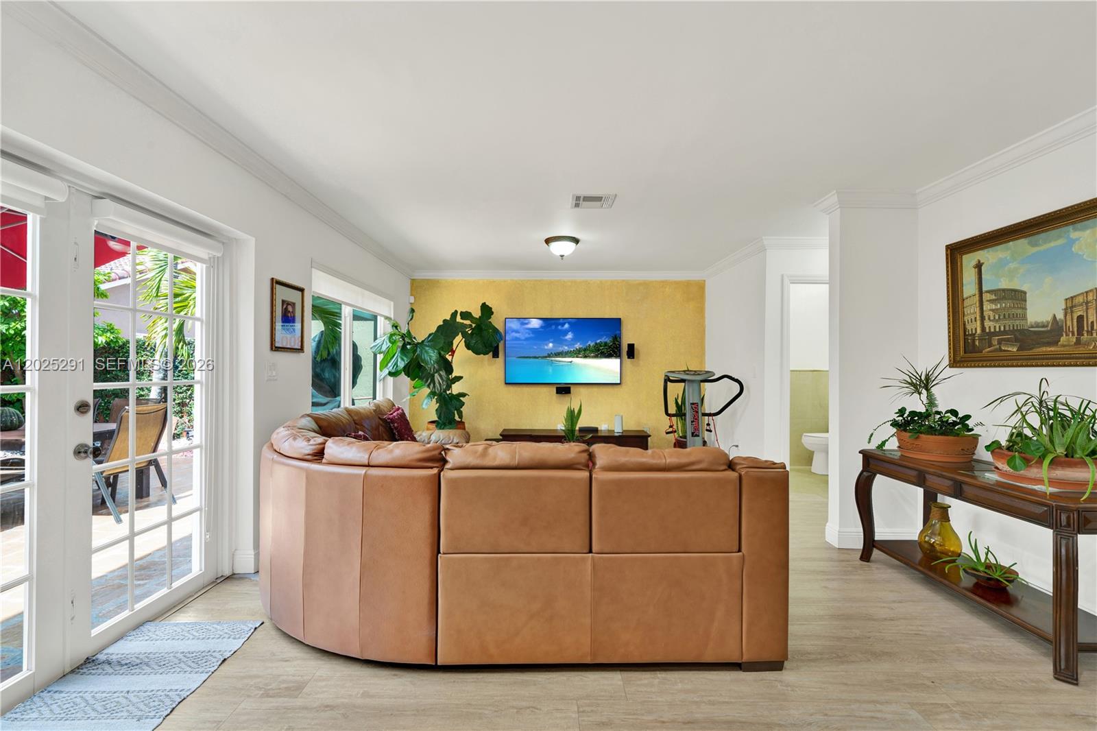 10006 Southwest 162nd Path Miami, FL 33196 - Photo 13 of 40 a living room with furniture a flat screen tv and a potted plant