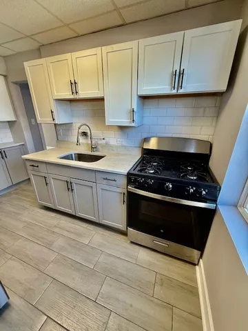 a kitchen with stainless steel appliances a stove a sink and a microwave