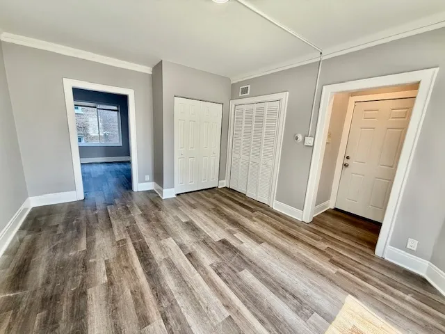 a view of bedroom with wooden floor