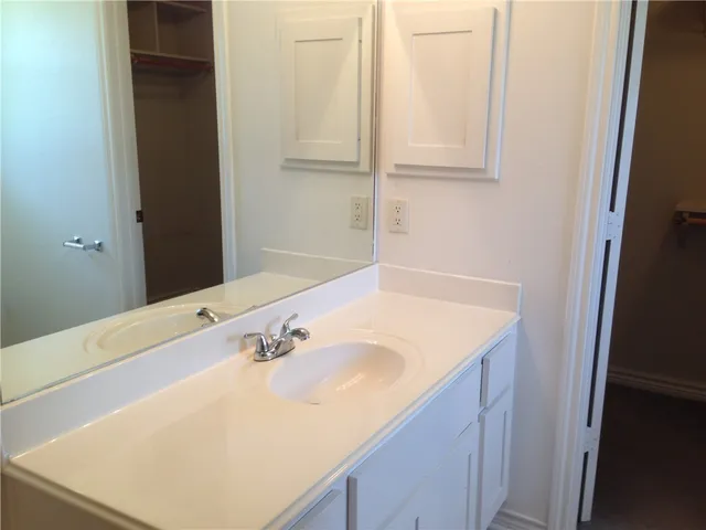 a bathroom with a sink and a white cabinet