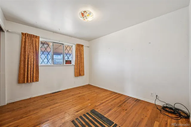 a view of a room with wooden floor and wall painting