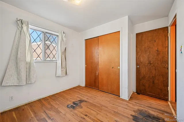 a view of empty room with window and wooden floor