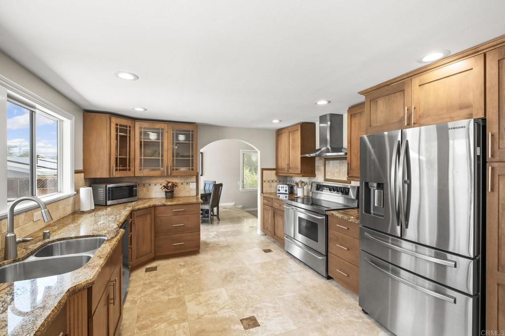 1973 Felicita Road Escondido, CA 92025 - Photo 16 of 55 a kitchen with stainless steel appliances granite countertop a refrigerator a stove a sink a dining table and chairs with wooden floor