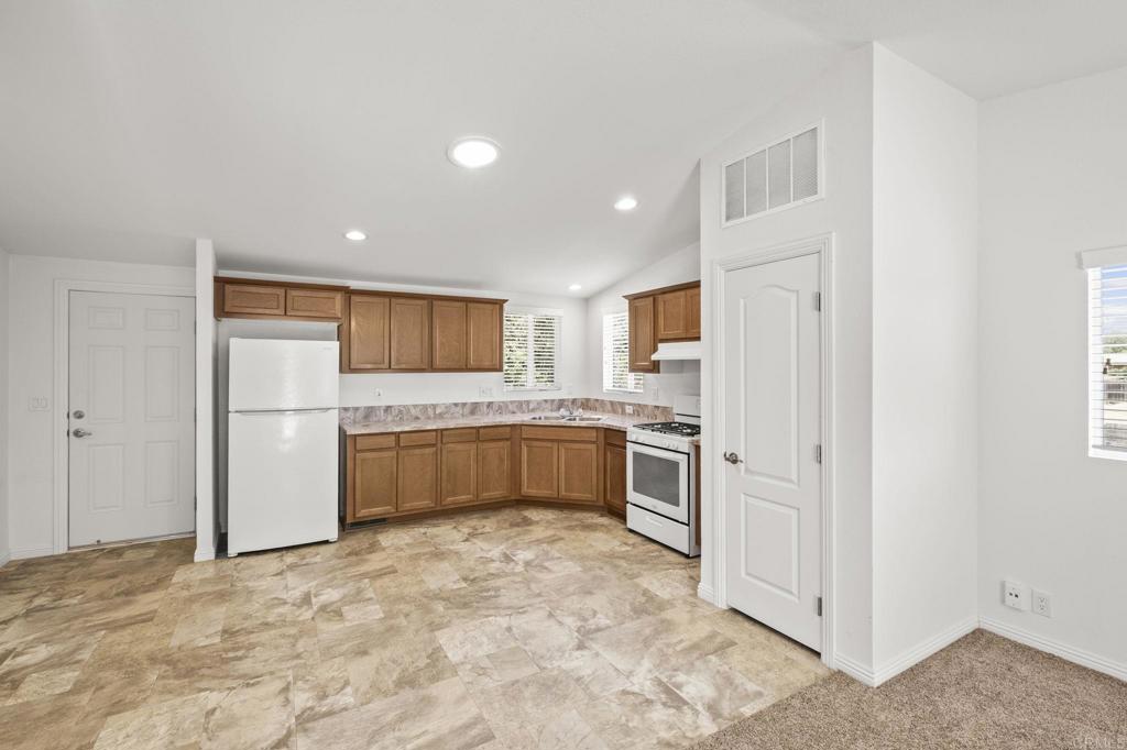 1973 Felicita Road Escondido, CA 92025 - Photo 46 of 55 a large white kitchen with cabinets and a refrigerator