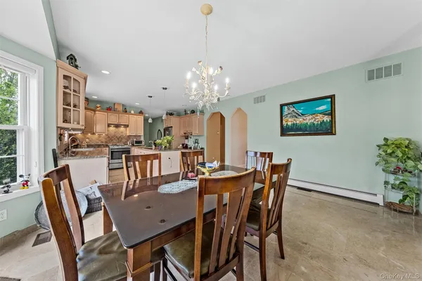a dining room with furniture a large window and a chandelier
