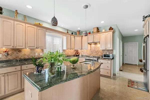 a kitchen with stainless steel appliances granite countertop a sink a stove and a wooden floors