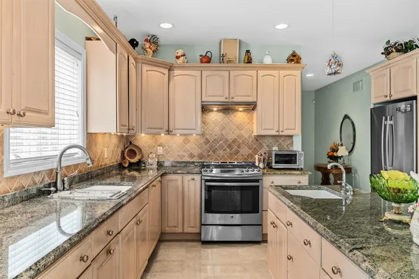 a kitchen with stainless steel appliances granite countertop a sink stove and refrigerator