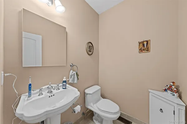 a bathroom with a sink mirror and toilet
