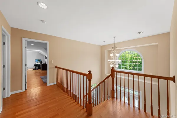 a view of a hallway with wooden floor and stairs