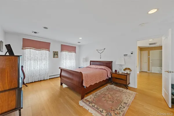 a bedroom with a bed rug and wooden floor