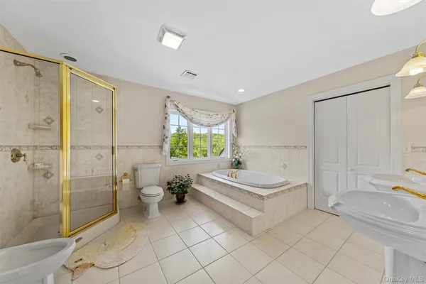 a spacious bathroom with a tub shower and toilet