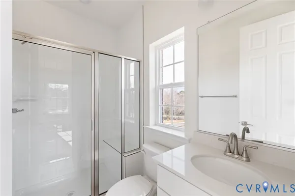 a bathroom with a sink toilet vanity and shower