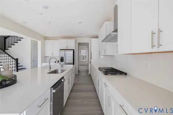a kitchen with granite countertop a sink a stove and refrigerator