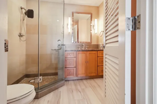 a bathroom with granite countertop double vanity and a mirror