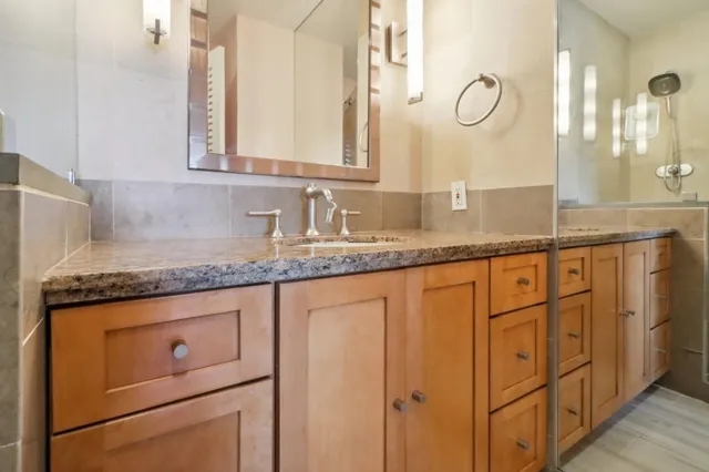 a bathroom with a granite countertop sink and a mirror