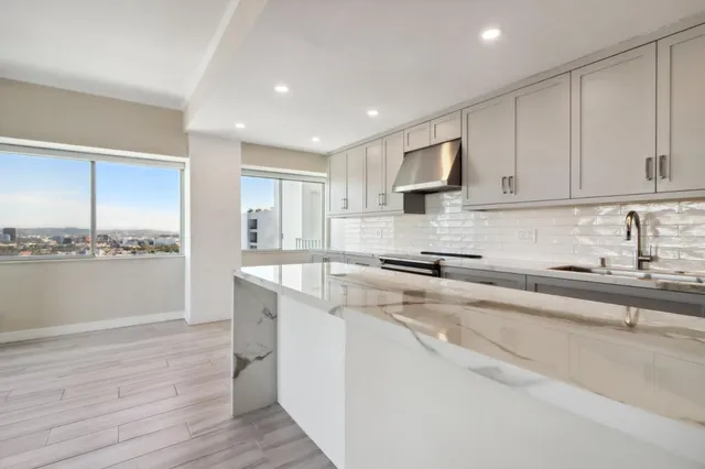 a kitchen with a sink a stove and cabinets