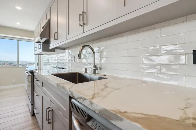 a kitchen with stainless steel appliances granite countertop a refrigerator and a sink