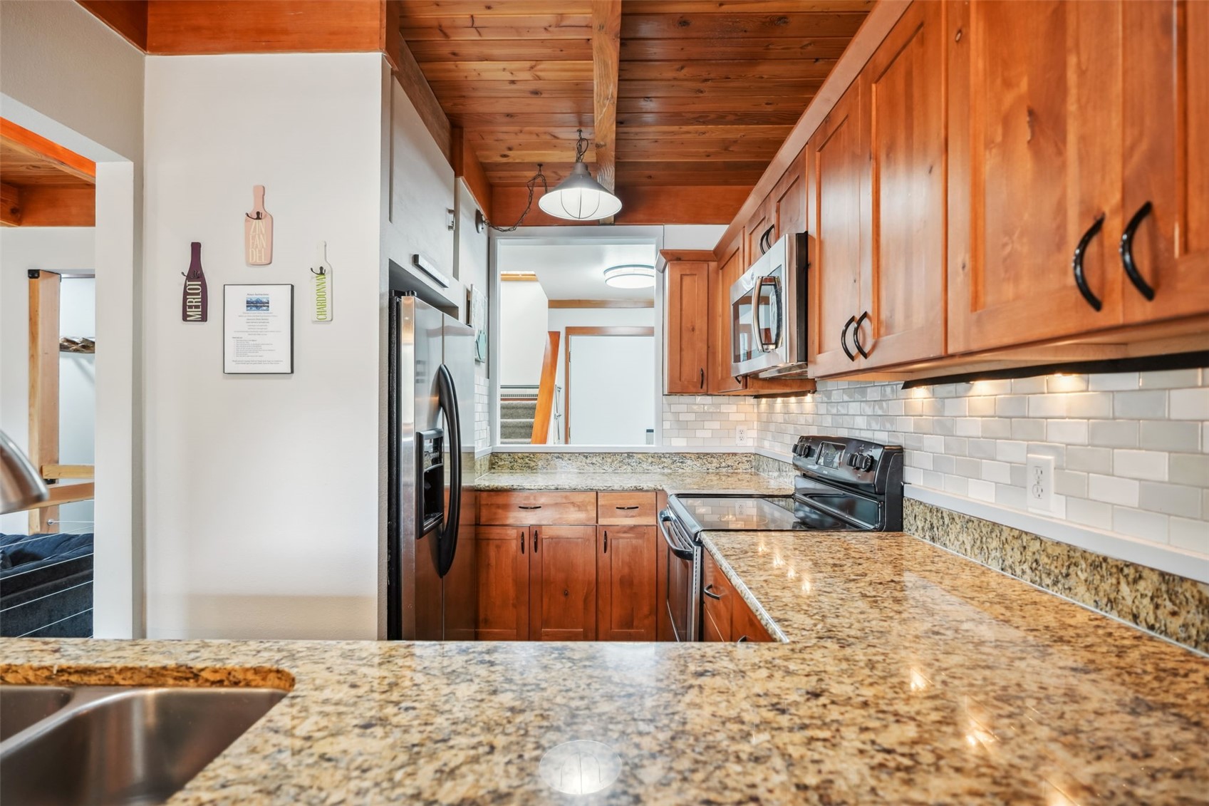 530 Tennis Club Road, Unit 1328 Keystone, CO 80435 - Photo 10 of 43 Kitchen featuring a sink, appliances with stainless steel finishes, decorative backsplash, and brown cabinetry