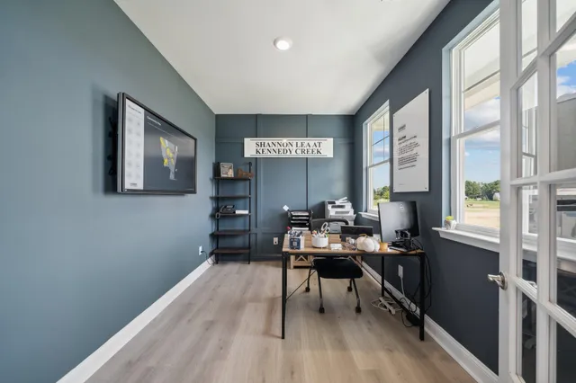 a workspace with furniture and a large window
