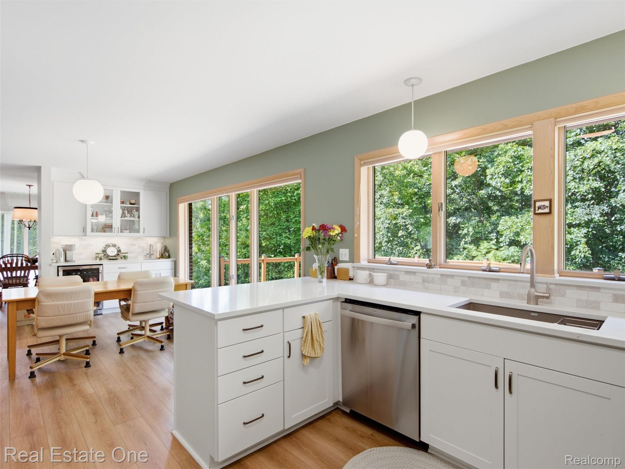 2626 West Wattles Road Troy, MI 48098 - Photo 17 of 65 Spacious kitchen featuring an island, white cabinetry, integrated stainless steel appliances, and wood-finish flooring