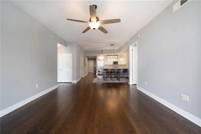 a view of a livingroom with wooden floor and a ceiling fan