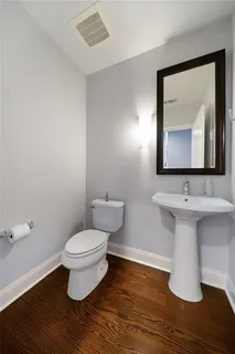 a bathroom with a toilet sink and mirror