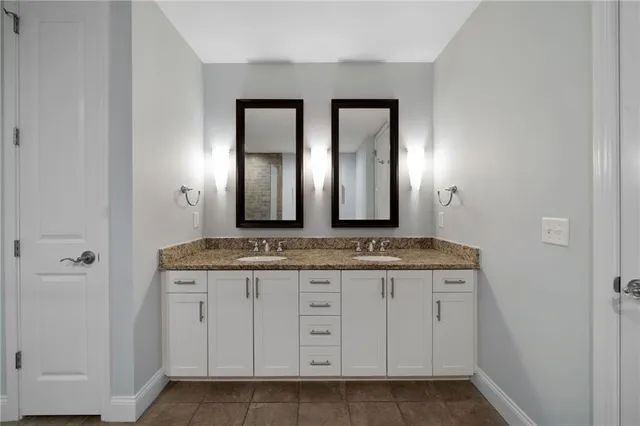 a bathroom with a granite countertop sink two mirror and a