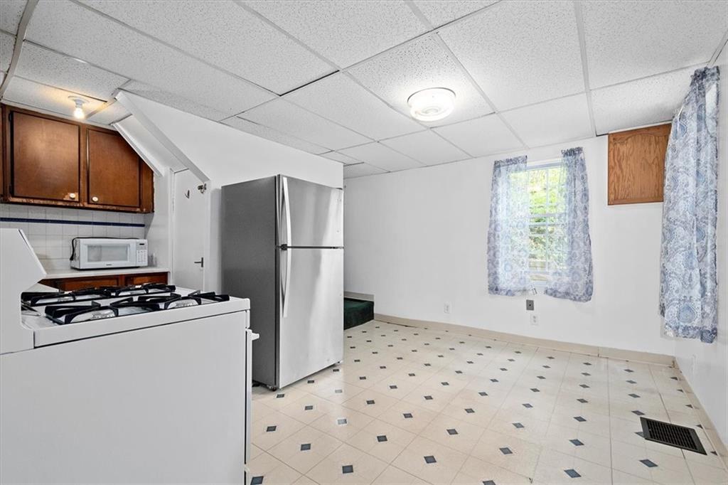 3212 Millers Run Road Cecil, PA 15321 - Photo 10 of 25 a kitchen with a refrigerator a stove a microwave and cabinets