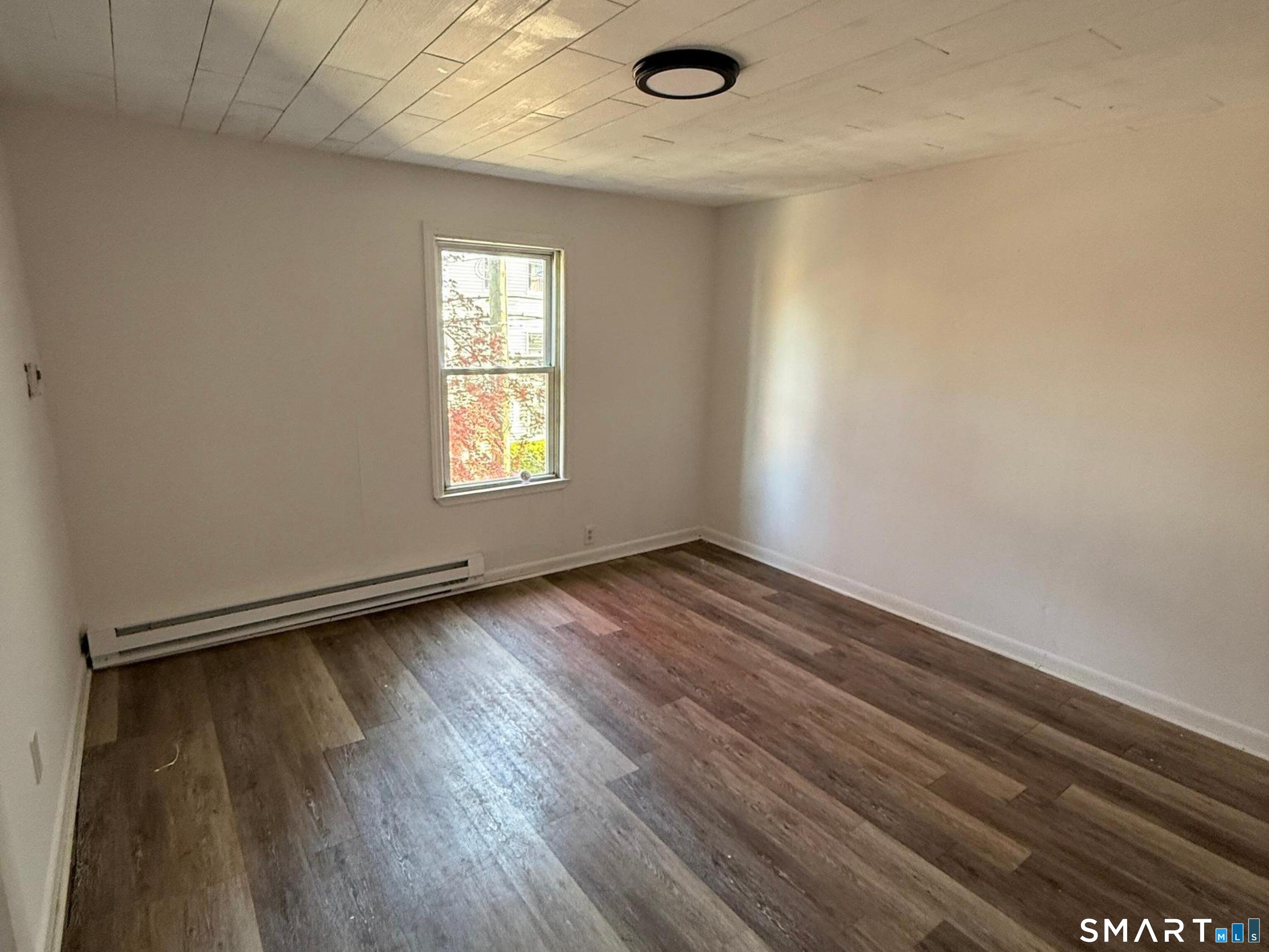 33 Olive Street Meriden, CT 06450 - Photo 4 of 10 an empty room with wooden floor and windows
