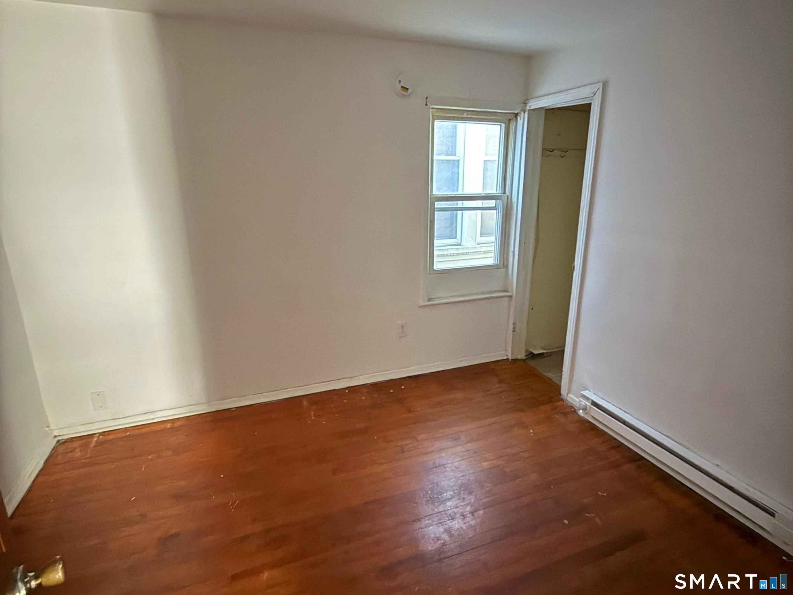33 Olive Street Meriden, CT 06450 - Photo 6 of 10 an empty room with wooden floor and windows