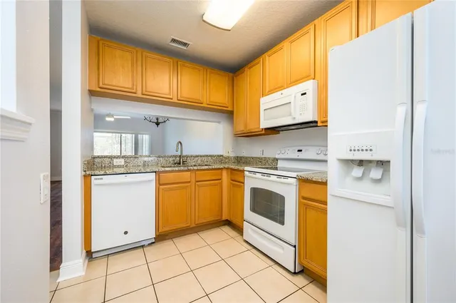 a kitchen with stainless steel appliances granite countertop a sink and cabinets